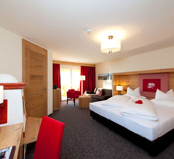 Das mit modernen Holzakzenten ausgestattete Schlafzimmer der Suite Nathalie im Hotel Bergheimat