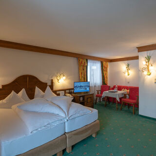 a freshly made double bed in the living and sleeping area of the spacious double room Hochkeil