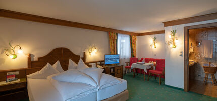 a freshly made double bed in the living and sleeping area of the spacious double room Hochkeil