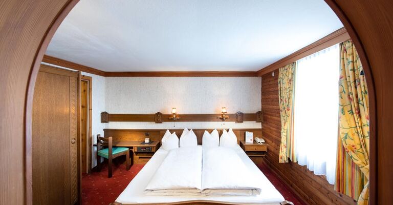 The rustic furnishings of the Birgkar double room with its large double bed next to the window