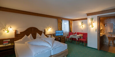 a freshly made double bed in the living and sleeping area of the spacious double room Hochkeil