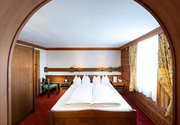 The rustic furnishings of the Birgkar double room with its large double bed next to the window