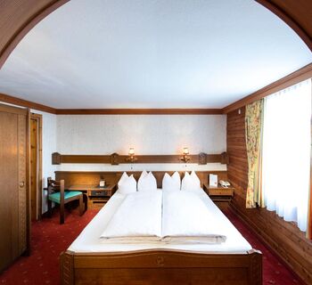 The rustic furnishings of the Birgkar double room with its large double bed next to the window