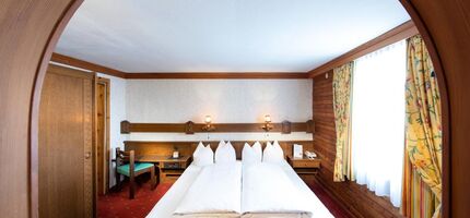 The rustic furnishings of the Birgkar double room with its large double bed next to the window