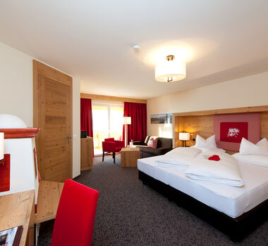 The bedroom of the Nathalie Suite in the Hotel Bergheimat, furnished with modern wood accents.