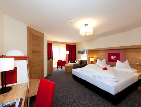 The bedroom of the Nathalie Suite in the Hotel Bergheimat, furnished with modern wood accents.