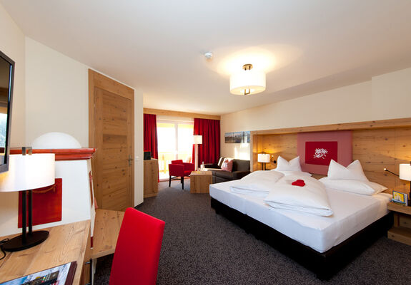 De slaapkamer van de Nathalie Suite in Hotel Bergheimat, ingericht met moderne houtaccenten.