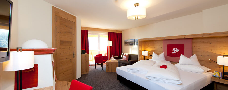 The bedroom of the Nathalie Suite in the Hotel Bergheimat, furnished with modern wood accents.