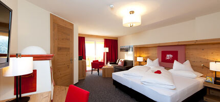 The bedroom of the Nathalie Suite in the Hotel Bergheimat, furnished with modern wood accents.