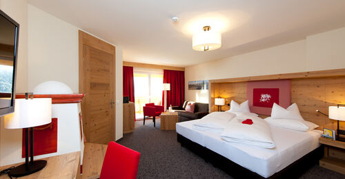 The bedroom of the Nathalie Suite in the Hotel Bergheimat, furnished with modern wood accents.