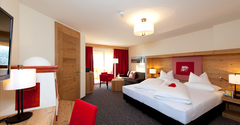 The bedroom of the Nathalie Suite in the Hotel Bergheimat, furnished with modern wood accents.