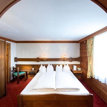 The rustic furnishings of the Birgkar double room with its large double bed next to the window