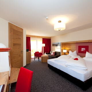 The bedroom of the Nathalie Suite in the Hotel Bergheimat, furnished with modern wood accents.