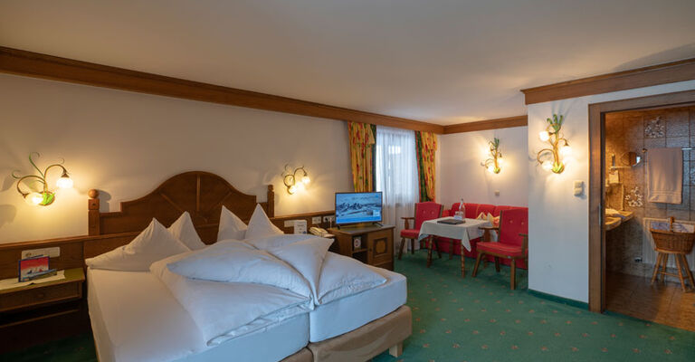 a freshly made double bed in the living and sleeping area of the spacious double room Hochkeil