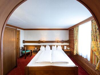 The rustic furnishings of the Birgkar double room with its large double bed next to the window