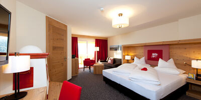 The bedroom of the Nathalie Suite in the Hotel Bergheimat, furnished with modern wood accents.