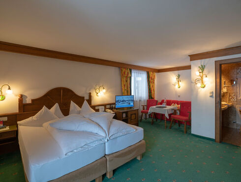 a freshly made double bed in the living and sleeping area of the spacious double room Hochkeil