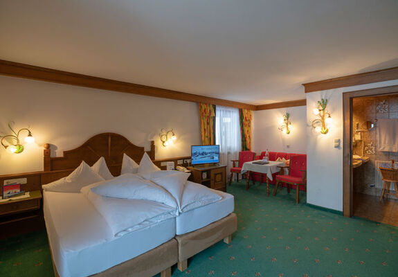 a freshly made double bed in the living and sleeping area of the spacious double room Hochkeil