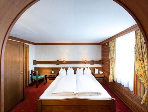 The rustic furnishings of the Birgkar double room with its large double bed next to the window