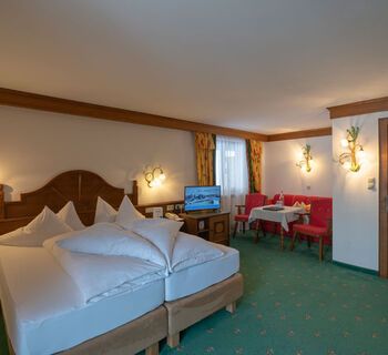 a freshly made double bed in the living and sleeping area of the spacious double room Hochkeil