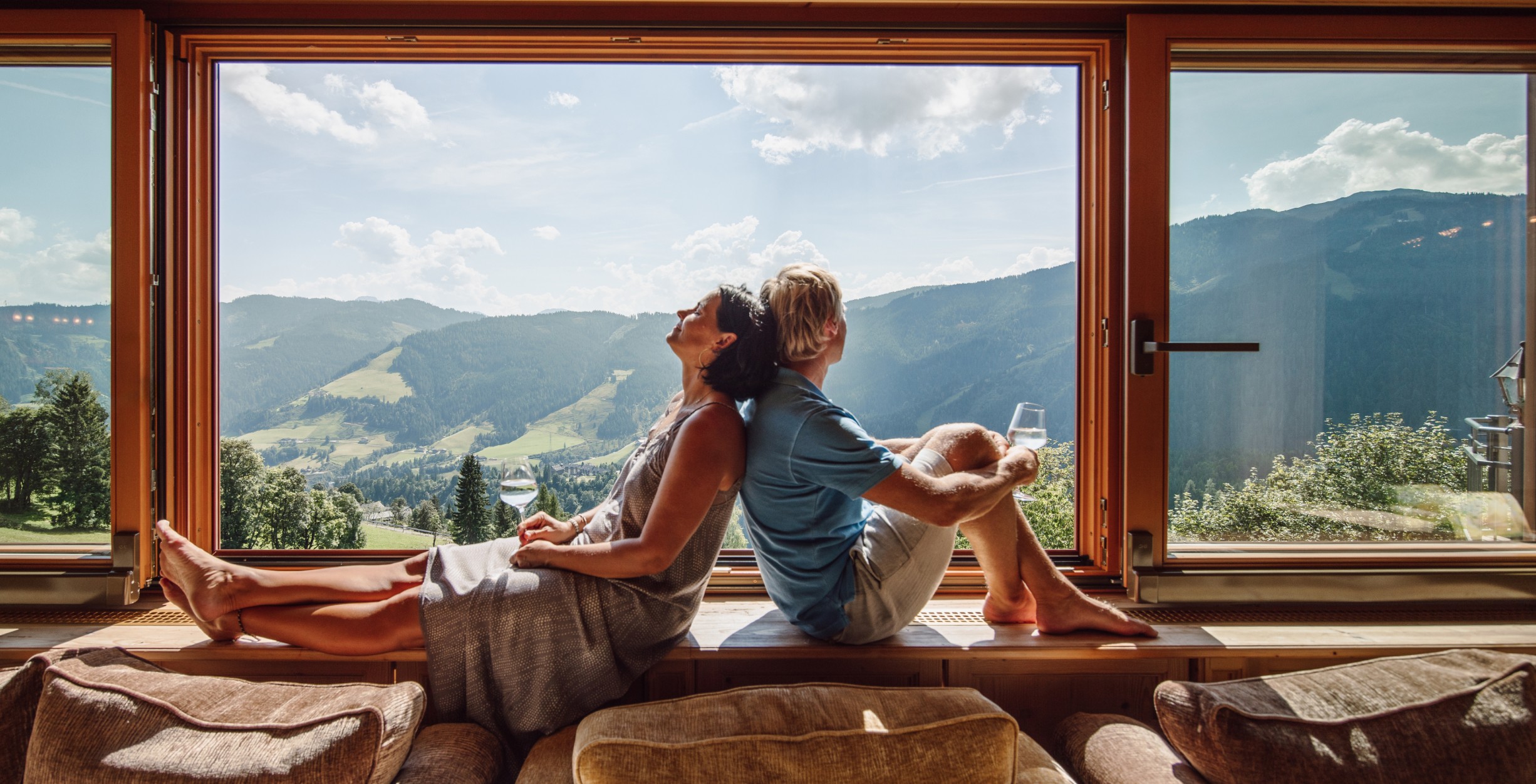 Paar entspannt an den großen Fenstern mit Weitblick