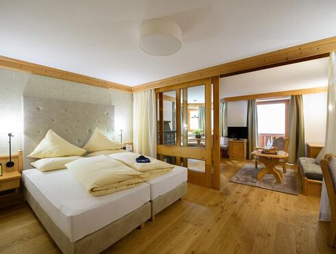 Stor suite med soveværelse og opholdsstue på Hotel Bergheimat am Hochkönig