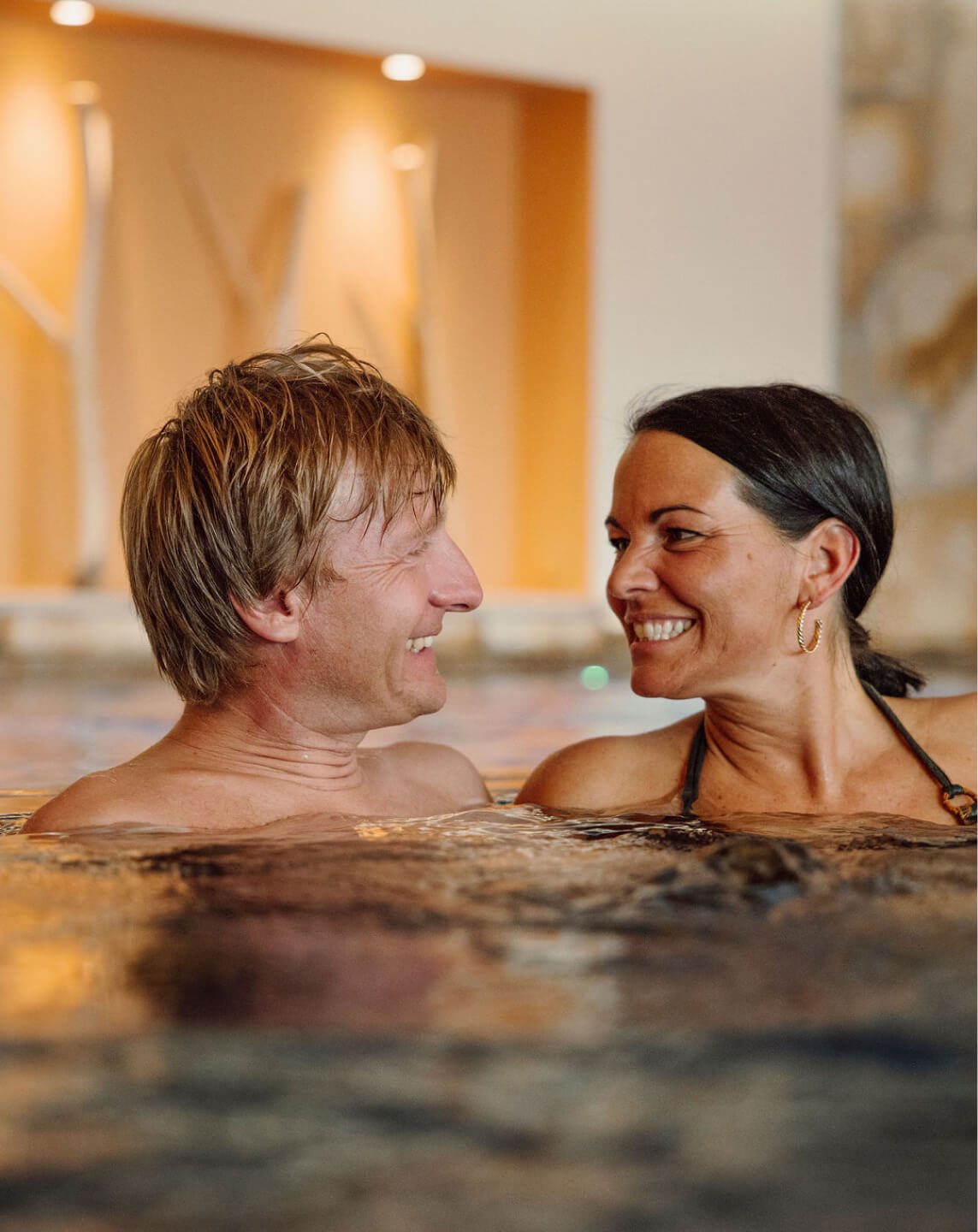Paar genießt entspannte Momente im warmen Innenpool der Bergheimat