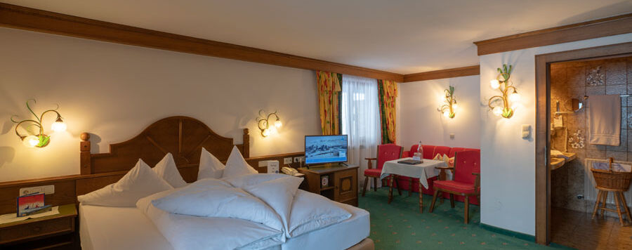 a freshly made double bed in the living and sleeping area of the spacious double room Hochkeil