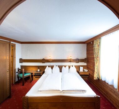 The rustic furnishings of the Birgkar double room with its large double bed next to the window