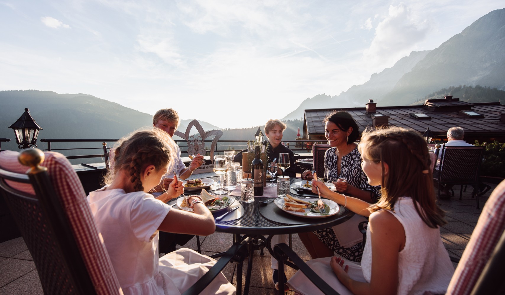 Abendessen einer Familie im Sommer auf der Terrasse der Bergheimat