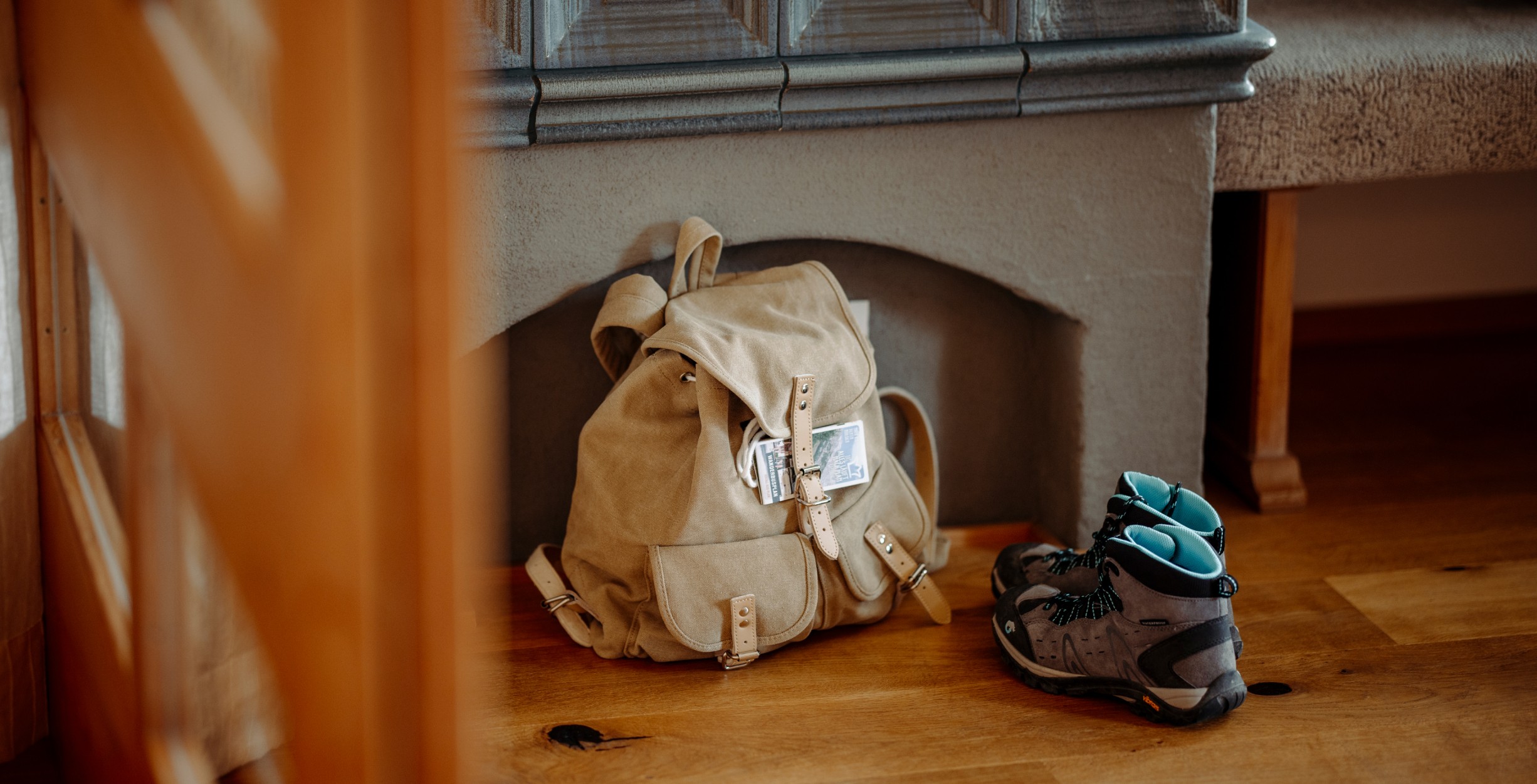Rucksack mit Wanderschuhen vor dem Kamin